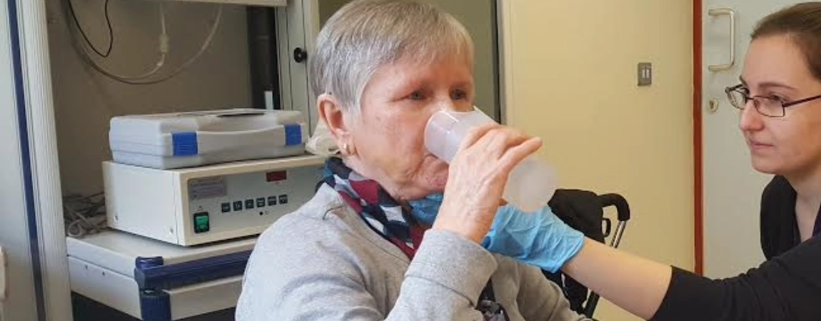 Lady being helped with a glass of water