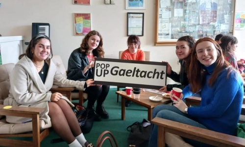 A group of Irish-speaking students holding a 'Pop Up Gaeltacht' sign.